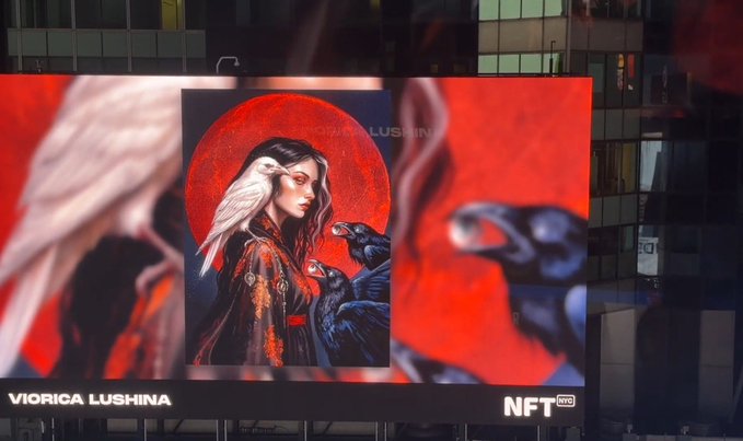 A digital billboard in an urban setting displaying artwork of a woman with a white bird on her shoulder, with the text "VIORICA LUSHINA" and "NFT NYC".