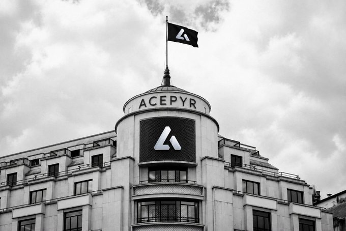 A black-and-white photograph shows an ornate building with the name "ACEPYR" on its facade and a matching flag flying from the roof, featuring a stylized "A" logo.