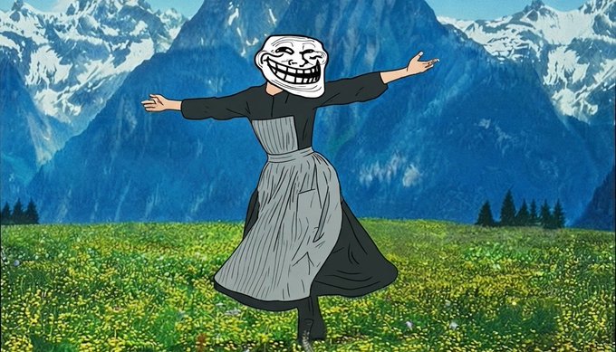 The image shows a figure wearing a trollface mask—a famous internet meme—paired with a dress, twirling joyfully in a picturesque alpine meadow with snow-capped mountains in the background. This visual ties directly to the post promoting the $TROLL memecoin, illustrating how the token is built around one of the most recognizable and iconic memes in internet history.