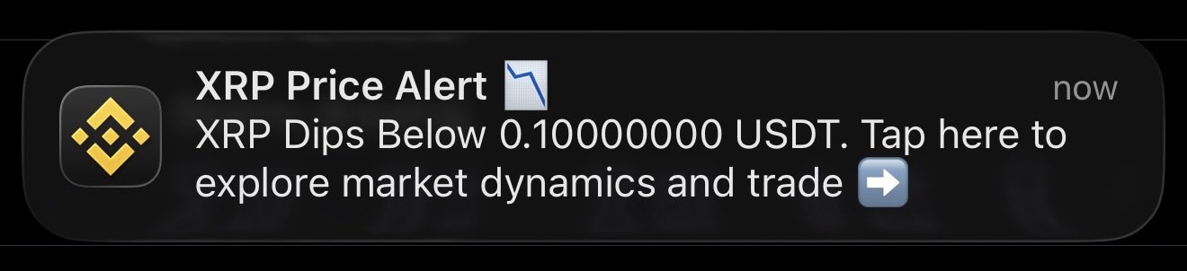 Binance price alert notification showing 'XRP Price Alert' with a downward trend icon and text 'XRP Dips Below 0.100000000 USDT. Tap here to explore market dynamics and trade'.