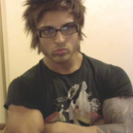 An 'emo teenager' meme photo showing a young man with spiky hair, glasses, and a black graphic t-shirt giving an annoyed side-eye stare.