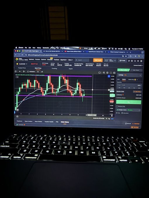 A laptop screen displaying a cryptocurrency or stock trading chart with candlestick patterns on a website, with the keyboard visible in the foreground.