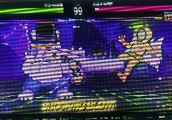 A screenshot from a fighting video game shows a character kicking an opponent, with the name "SHOCKINGBLOOM" displayed at the bottom.