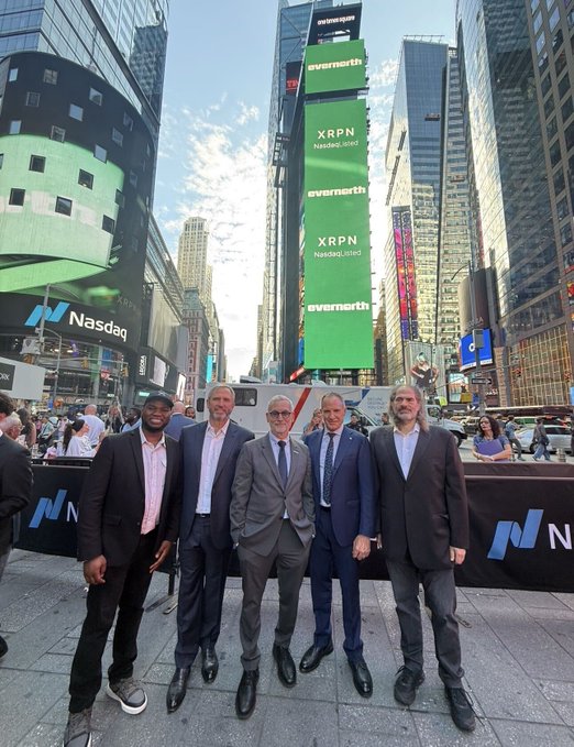 Five men in business suits pose together in front of the Nasdaq building in Times Square, with 'XRPN NasdaqListed' and 'evernorth' displayed on the green billboards behind them.