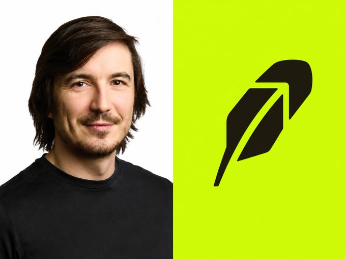 A man with dark hair and a goatee, wearing a black shirt, smiles against a white background, positioned next to the Robinhood logo—a black feather icon on a bright lime green backdrop—visually representing the post's discussion of Robinhood's expanding crypto offerings and bullish sentiment from CEO Vlad Tenev.