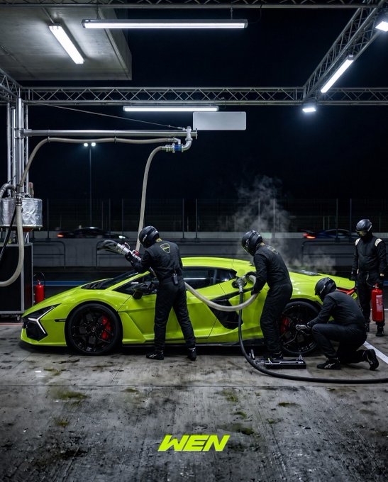 A pit crew in black uniforms servicing a bright lime-green Lamborghini at a nighttime pit stop, with crew members refueling and changing tires, branded with 'WEN' at the bottom.