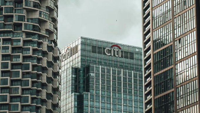 A view of modern city skyscrapers against a cloudy gray sky, with two buildings prominently displaying the "citi" logo with its signature red arc.