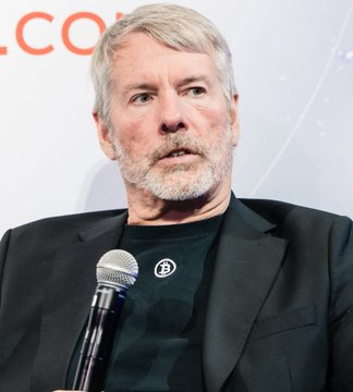 The image features a man wearing a black suit, standing against a white background with a microphone in front of him. The man appears to be speaking or addressing an audience, as he holds the microphone close to his mouth. There are also some words written on the wall behind him that read "Bitcoin Utility" and "Don't worry ... $DOGE already fixed that problem". This suggests that the image is related to a discussion about Bitcoin or cryptocurrency, possibly at a conference or event.

The man's attire and the presence of the microphone indicate that he might be an expert in the field or someone who has valuable insights to share with others. The words on the wall further emphasize this notion by stating that Bitcoin Utility already fixed a problem related to Bitcoin.