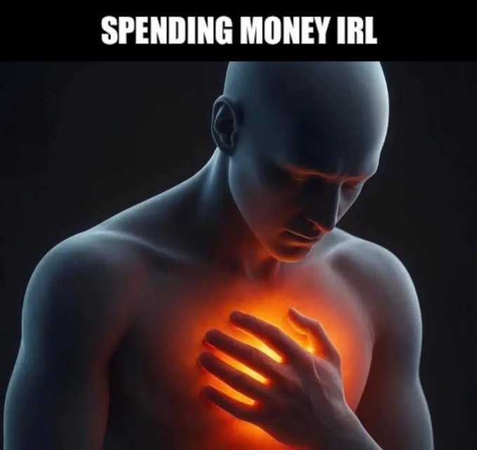 A bald 3D-rendered figure clutches their chest as it glows bright orange, captioned "SPENDING MONEY IRL." The image visually captures the post's metaphor of how spending money in real life feels like a literal stab in the chest, while casually losing six figures on crypto or gambling somehow doesn't register the same way.