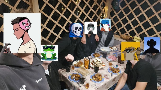A group of people sitting around a dinner table laden with food in a wooden lattice room, with their faces covered by various cartoon and meme stickers including a skull, Pepe frog, and cartoon characters.