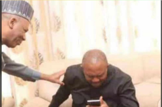 A man in traditional attire consoles a tearful, overwhelmed man sitting on a couch staring at his phone. The image humorously captures the exaggerated emotion of someone who missed out on a 100x crypto gain promoted by KOL signals on Bitget Wallet.
