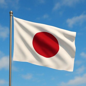 The image shows the Japanese flag—a white banner with a red circle—waving against a blue sky, symbolizing Japan in light of the news that the country has passed a landmark bill classifying crypto as a financial asset, paving the way for Bitcoin ETFs and a flat tax rate of around 20%.