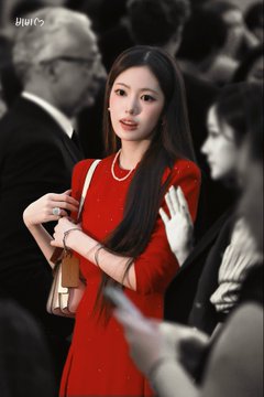 A stylish woman in a bright red dress and pearl necklace holds a tan handbag in a formal event setting, with the 'jiuse' watermark visible in the corner.