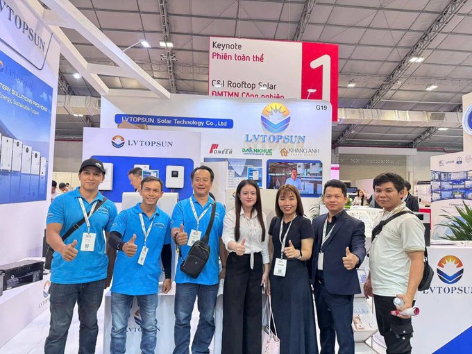 A group of seven people pose with thumbs up in front of the LVTOSUN Solar Technology Co., Ltd. booth at a trade show, with signage indicating 'Keynote' and 'C&I Rooftop Solar' in both English and Vietnamese.