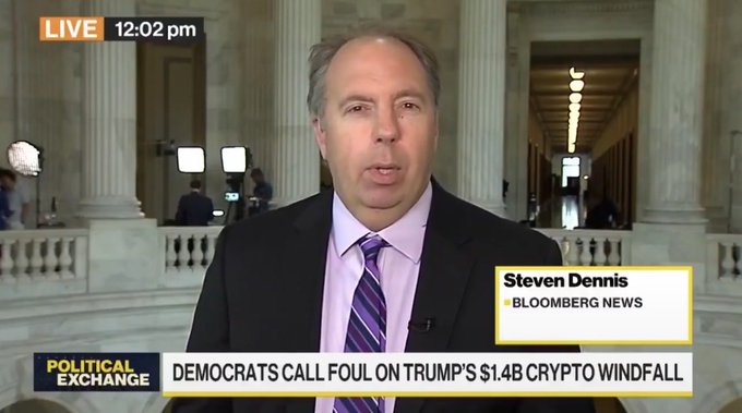 A Bloomberg News live broadcast featuring correspondent Steven Dennis reports on "Democrats Call Foul on Trump's $1.4B Crypto Windfall," with a chyron noting the broadcast airs at 12:02 pm during the "Political Exchange" segment. The image, showing a reporter at the U.S. Capitol, connects to the accompanying post about Republican Senator Thom Tillis and Democratic Senator Ruben Gallego's compromise on ethical provisions in the Clarity Act, highlighting ongoing congressional negotiations over cryptocurrency legislation that involves Trump-related financial interests.