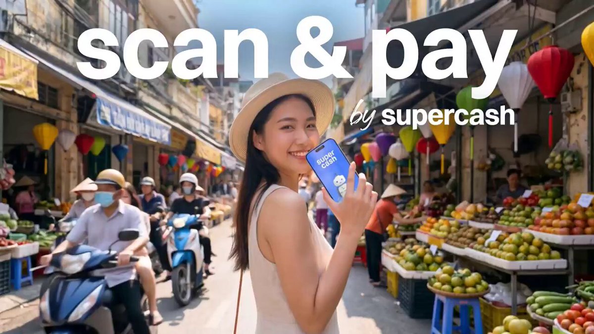 The image features a woman standing next to a fruit stand with various fruits such as bananas, apples, and oranges displayed for sale. She is holding up her cellphone displaying an advertisement or promotional message related to scanning and paying using Super Cash. The text on the image suggests that she can use her smartphone to scan the Super Cash card directly from the device while shopping at supermarkets or other establishments. This modern approach to payment offers convenience, as it eliminates the need for carrying cash or credit cards and allows users to quickly and easily pay for their purchases with just a simple scan of their phone.