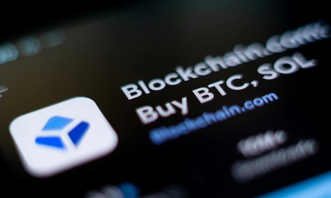 A close-up of a screen showing a crypto exchange app with the text 'Blockchain.com' and 'Buy BTC, SOL' next to a blue logo.