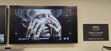 An AWS Skills Center Arlington display screen showing an artistic image of hands reaching toward a face covered by a digital mask.