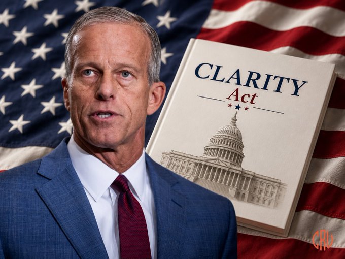 Senate Majority Leader John Thune appears beside a document titled "CLARITY Act" featuring an image of the Capitol building, set against an American flag backdrop, illustrating his announcement that a procedural vote on the CLARITY Act could occur before the Senate recess.