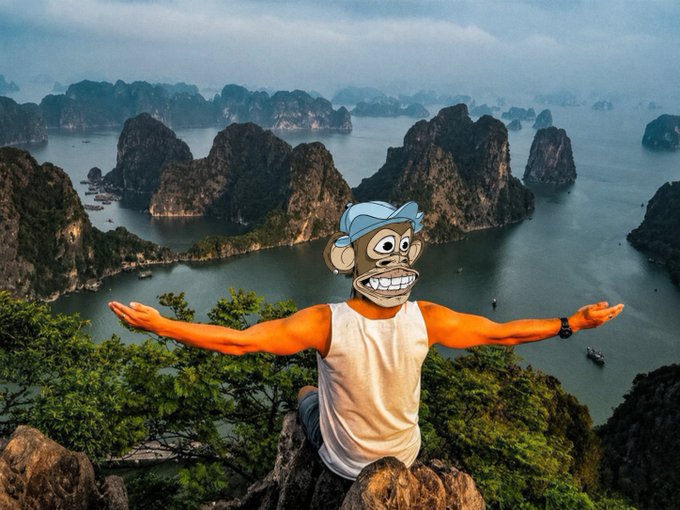 A Bored Ape Yacht Club (BAYC) NFT character with a blue cap and white tank top strikes a triumphant pose with arms outstretched against the stunning backdrop of Halong Bay's limestone karsts in Vietnam, promoting weekend travel and community connection across the BAYC, MAYC, and Yuga Labs ecosystems.