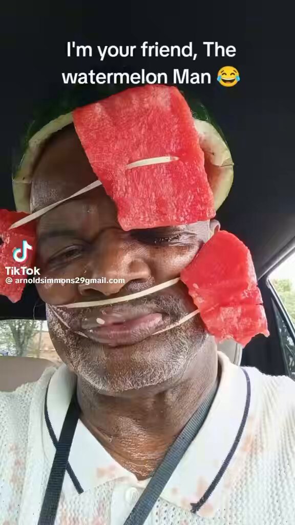 The image features an older man wearing a white polo shirt with watermelon slices stuck to his face, including one slice on each ear. The man appears to be smiling at the camera while holding up the watermelon slices as if they were a part of his outfit or a statement. The caption below the photo reads "Pumpfun was a mistake for humanity", which suggests that the man's watermelon-covered appearance is meant to be humorous and lighthearted, rather than a serious or somber message.