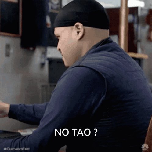 The image features an actor wearing a black hat, sitting at a desk with their back facing the camera while looking down at something on the desk. The caption of the image reads "No tofu?" which seems unrelated to the main subject matter.