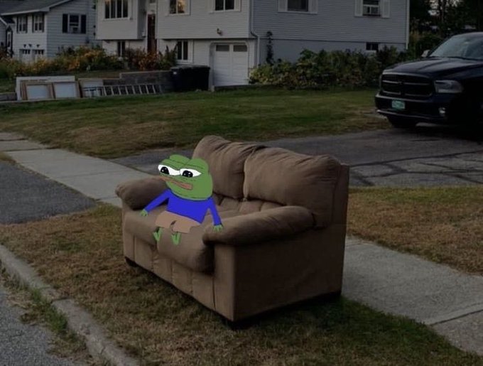 A meme-style image of the Pepe the Frog character sitting on a brown armchair placed on a residential curb.
