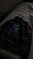 A black satin jacket with a cyan "S" logo and partial text visible rests on a white bed, seemingly related to a Solana-themed anime collaboration or merchandise drop where team members are receiving items.