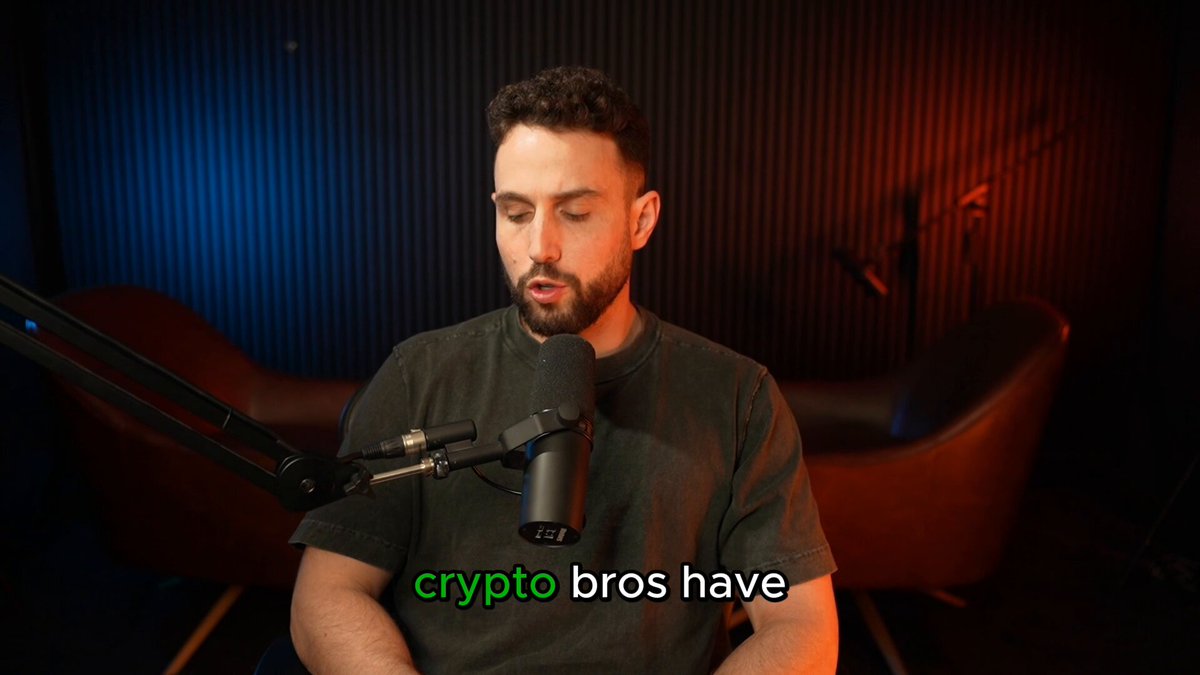 The image shows a man sitting at a desk with a microphone, wearing a green shirt that reads "Crypto bros have the worst take on Leopold buying $3B of Nebius" as part of his attire for an interview or podcast. The background reveals that the conversation is taking place in a room furnished with a couch and two chairs, suggesting an informal setting like a studio recording setup. The main focus should be on the content of the post related to the interview or discussion.