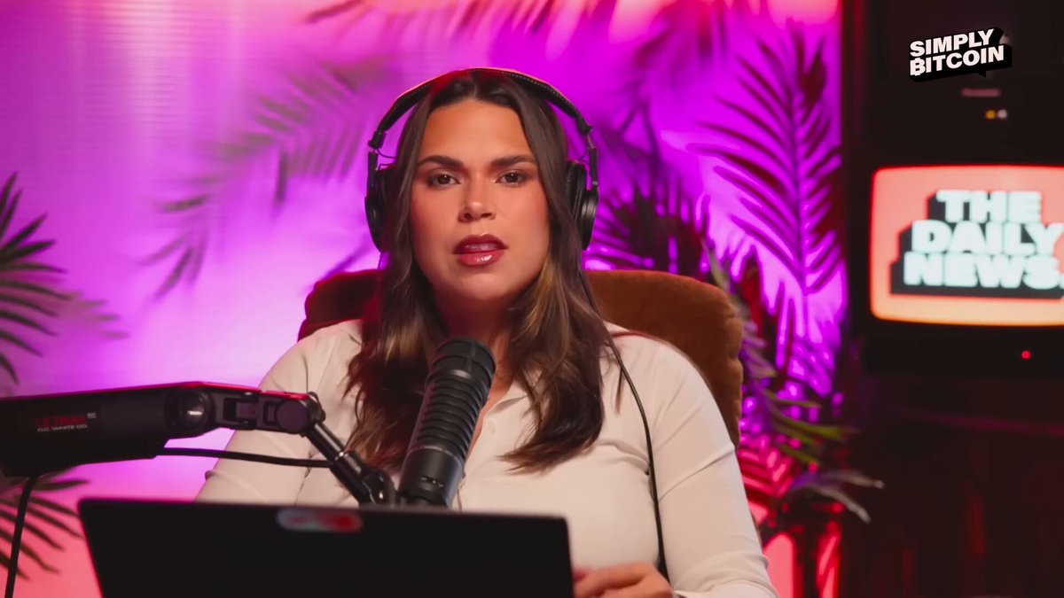 The image features a woman sitting behind a microphone, wearing headphones as she speaks into them. The background of the image shows a purple wall with palm trees, creating an atmosphere that could be related to a podcast or radio show. There are also two TVs in the scene - one on the left side and another on the right side.

The post includes text about Bitcoin and Jim Cramer's statement about it being dead. The woman is wearing headphones while speaking into them, which suggests she might be discussing this topic during her podcast or radio show.