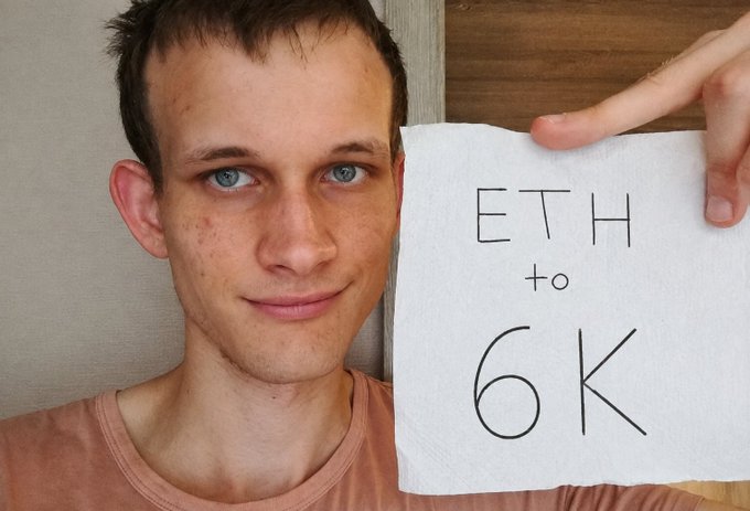 A young man with blue eyes holds up a handwritten sign reading "ETH to 6K," visually expressing his belief that Ethereum's price will climb to $6,000. The makeshift sign humorously ties into the "believe in somETHing" caption, playing on the word "ETH" within the phrase itself.