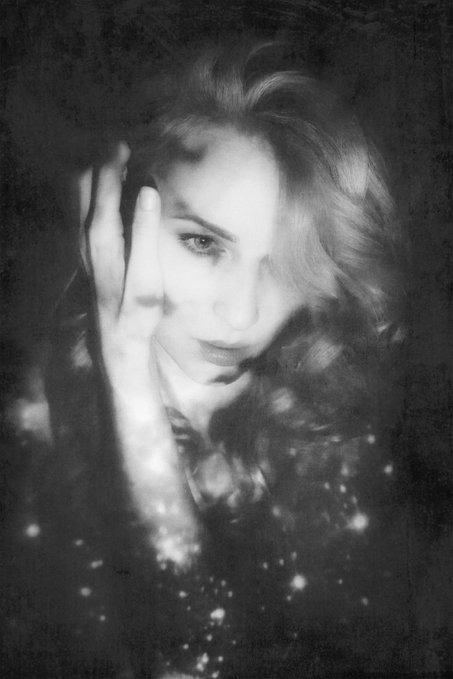 The image features a woman with long hair, wearing a black top, and her hand resting on her face. The photo has a vintage or aged appearance, giving it an artistic feel. The background of the image is dark, which further emphasizes the subject's presence in the frame. The caption "I have just collected" suggests that this image might be part of a collection or series by @natariaaa, and the post is titled "My Dark Side".