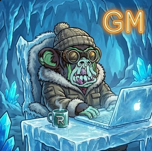 A cartoon monkey wearing a beanie and goggles sits at an icy desk with a steaming "R" mug, working on a laptop with a glowing neon "GM" sign in the background, representing the crypto community's classic "GM" (Good Morning) greeting often shared during trading campaigns like the @reya_xyz Streakers Competition.