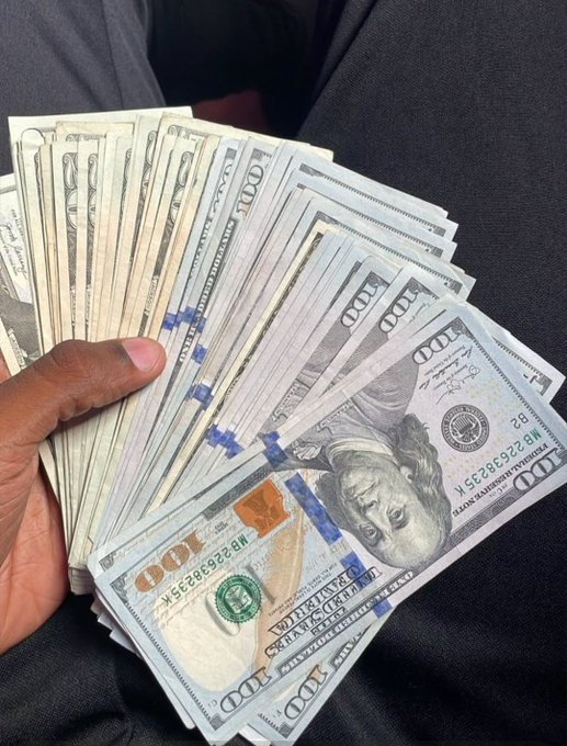 A hand fans out a thick stack of US $100 bills, suggesting the promise of giving away cash to the first 500 people who like the post before Saturday ends. The image reinforces the "free money" hook with a visual of what appears to be thousands of dollars in hand.

⚠️ **Caution:** This type of post is a common social media scam designed to collect likes, personal information, or trick users into sharing/sending money. No one gives away cash simply for liking a post.