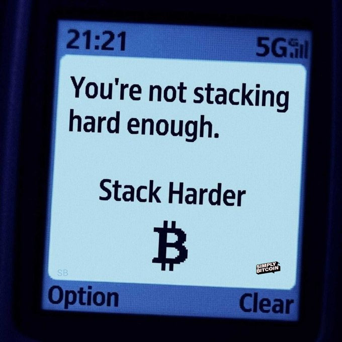 The image shows a cell phone screen with a message displayed, which reads "You're not stacking hard enough. Stack Harder." This message seems to be related to the concept of Bitcoin or cryptocurrency, as indicated by the text "Bitcoin". The context suggests that someone is trying to convey this message about Bitcoin in a humorous manner using an everyday object like a cell phone screen.