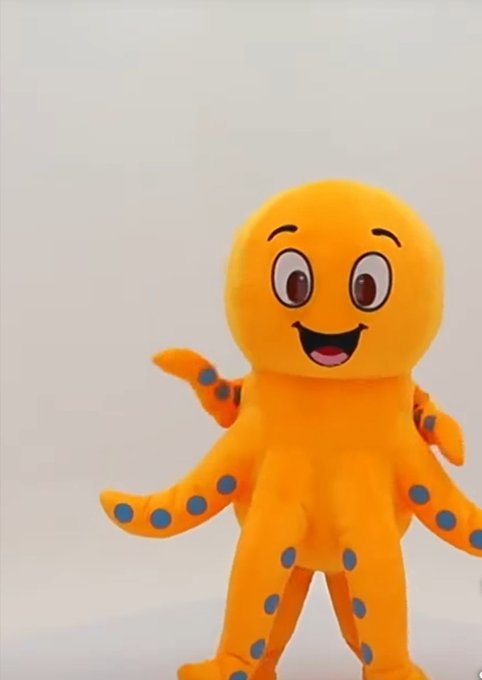 An orange octopus character with blue spots, large eyes, and a smiling expression stands against a white background.