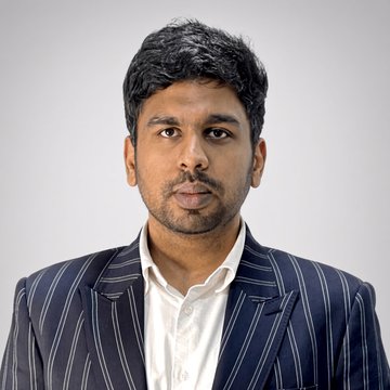 Ram Kumar, CEO of OpenLedger, appears in a professional headshot wearing a striped blazer over a white shirt, looking directly at the camera. The portrait accompanies a quote about his views on agentic payments and AI-driven crypto use cases shaping OpenLedger's future platform strategy.