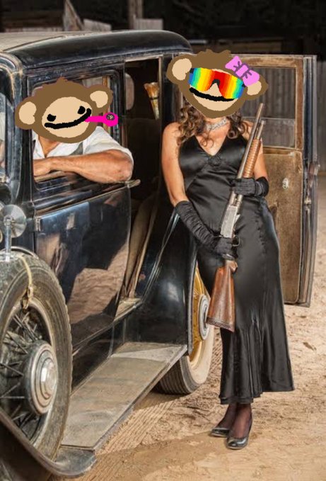 A vintage-style photograph of a woman in a black satin dress holding a rifle beside an antique black car, with another person visible in the driver's seat, both faces obscured by cartoon monkey stickers with sunglasses.
