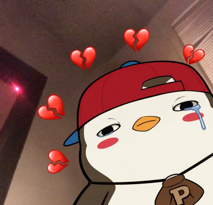 A cartoon penguin wearing a red backwards hat and a bell with the letter 'P' looks sad with drooping eyes, surrounded by several broken heart emojis in a dimly lit room.
