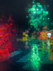 An abstract, colorful digital artwork or photograph with vibrant bokeh effects featuring green, red, and yellow orbs of light creating a dreamy, festive atmosphere.