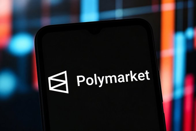 A smartphone displaying the Polymarket logo against a blurred background of colorful financial candlestick charts.