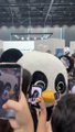 A person in a panda mascot costume takes a selfie with fans at what appears to be a convention or expo, while the post announces an "urgent matter" from "Brother A" with the hashtag #LUNAR, suggesting the panda character may be promoting or representing the LUNAR brand or event.