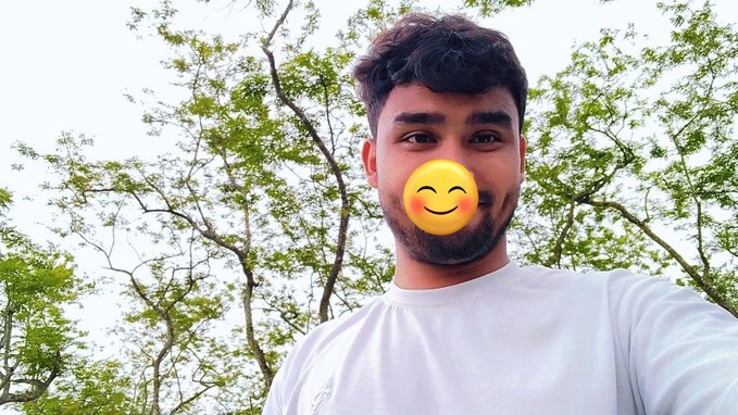 The image features a man with a yellow smiley face mask, which adds a fun and quirky element to his photo. The background of the picture consists of trees, giving the scene a natural and relaxed atmosphere. The caption provided for this image suggests that the focus should be on the simplicity and effectiveness of the mobile app being discussed in the post.