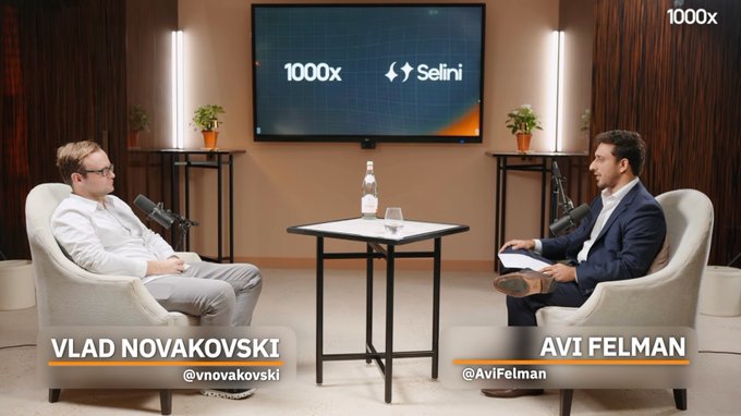 A podcast interview setup featuring Vlad Novakovski (@vnovakovski) and Avi Felman (@AviFelman) in armchairs, with a '1000x x Selini' logo displayed on the screen behind them.