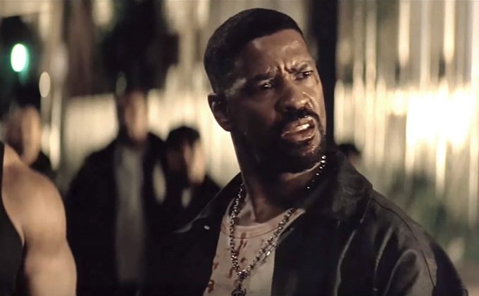 A still from a film showing Jamie Foxx with a bruised face and blood-stained shirt, wearing chains and a leather jacket in a dimly lit nighttime scene.
