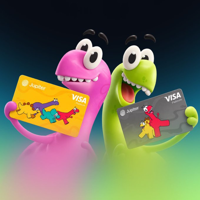 Two colorful 3D dinosaur mascots—one pink and one green—proudly display their Jupiter Visa Debit and Platinum cards, matching the announcement of Claynosaurz's partnership with Jupiter to launch the first of its kind branded Visa card.