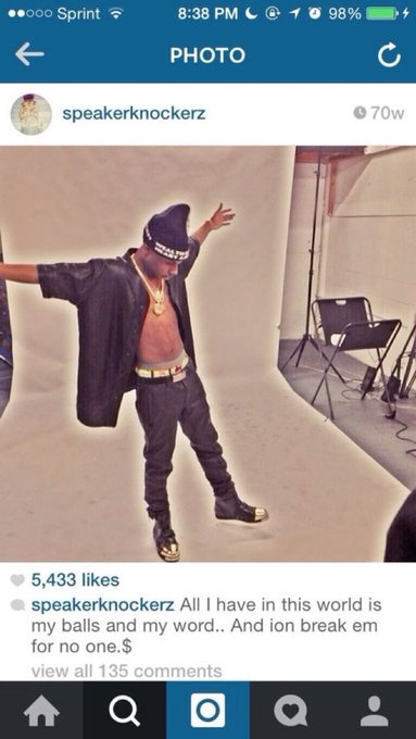 A screenshot of an Instagram post by 'speakernockerz' showing a shirtless man wearing a black knit cap and open shirt posing with outstretched arms in a photography studio, captioned with a line about having balls and word.