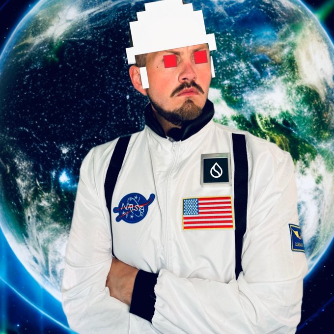A man in a white NASA spacesuit stands with crossed arms in front of an image of Earth, with his face obscured by pixelated red glasses and a white head graphic.