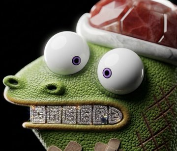 A whimsical 3D render of a green crocodile character with large googly eyes and a diamond-encrusted mouth, sitting in a tub of bubbles.