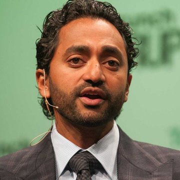 A man with curly dark hair and a beard speaks at a conference, likely Chamath Palihapitiya, expressing his bullish views on Bitcoin as a revolutionary form of "money 2.0."